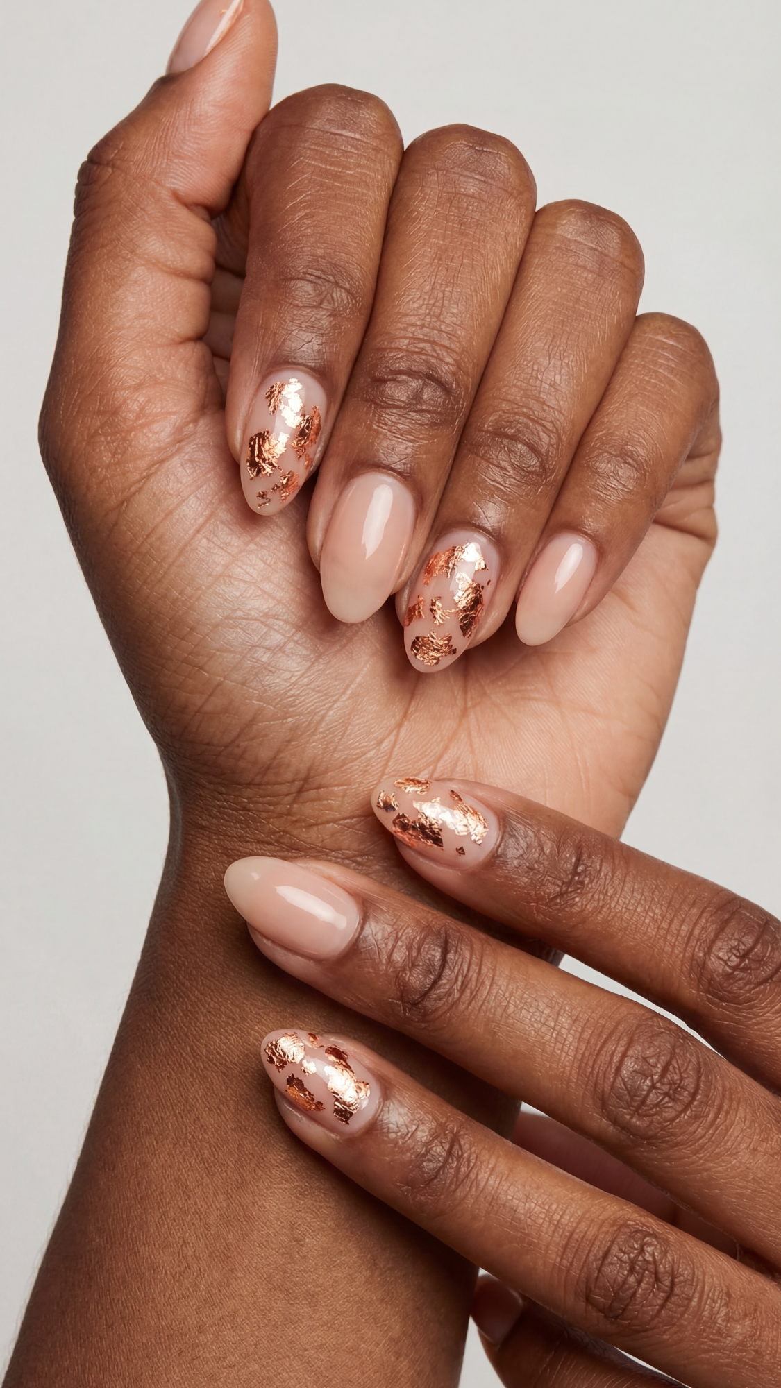 Copper Leaf Foil — “Short almond nails with sheer nude base and delicate irregular copper foil flakes sealed under glossy topcoat.”
