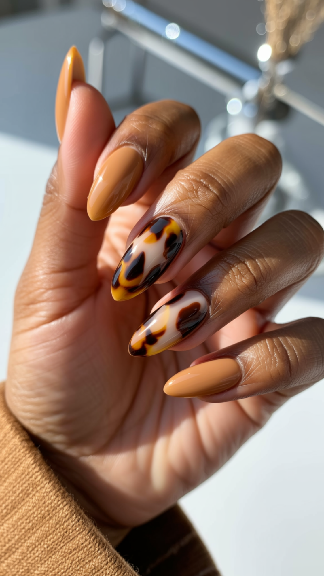 Tortoiseshell Accents — “Almond-shaped nails with honey-colored base and two nails featuring layered chocolate and black tortoiseshell spots under a glossy glaze.”

