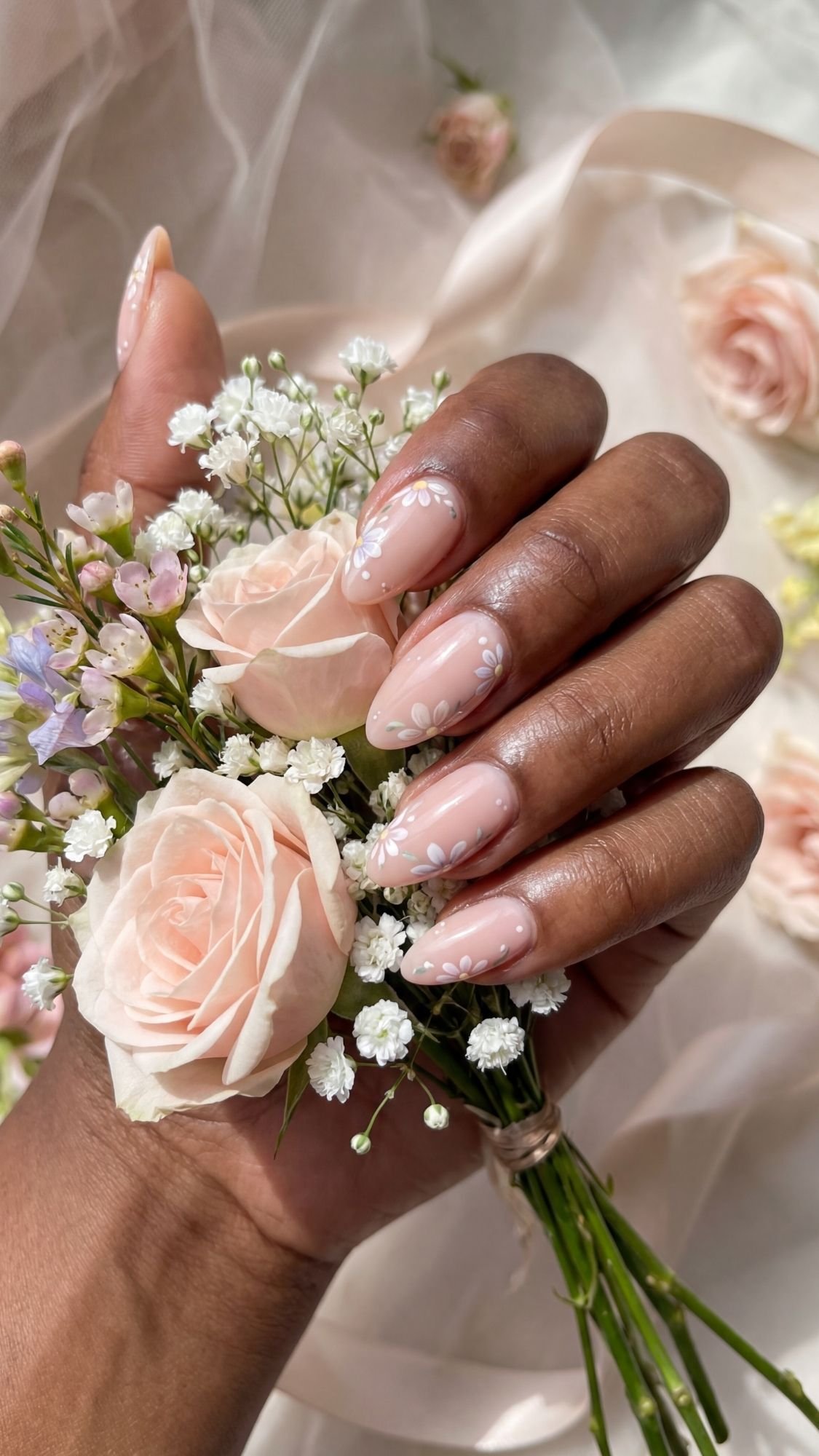 Coquette Floral Almond Tips — Almond nails dotted with tiny clustered pastel floral accents near tips.