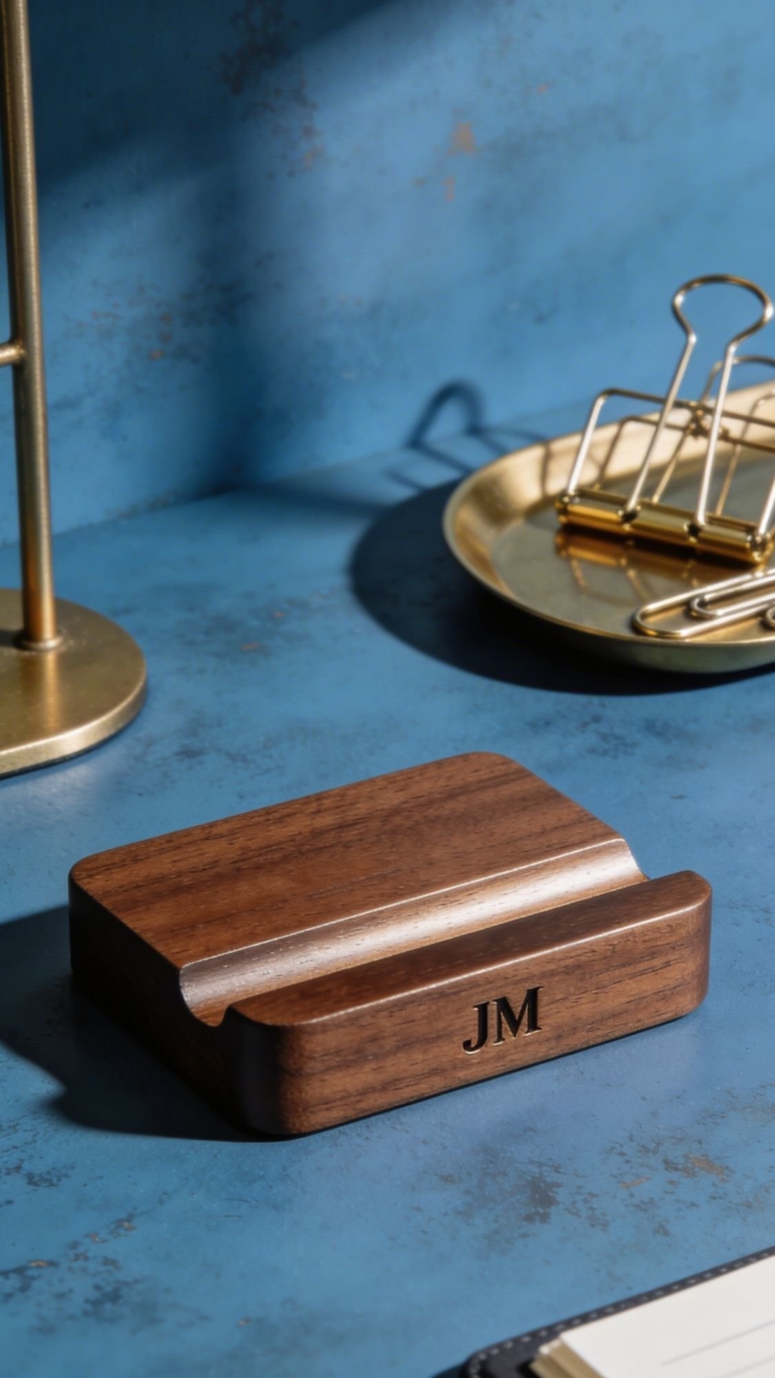 A wooden desk organizer with the initials JM engraved on it sits on a blue surface, next to gold office accessories—one of those handmade gift ideas and best friend gifts they'll actually use every day.