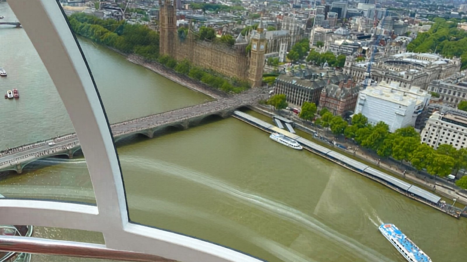 View from a glass-enclosed cabin above the River Thames, showing Westminster Bridge, boats on the water, the Houses of Parliament, and city buildings—a must-see for your first trip to London and a highlight among London things to do.
