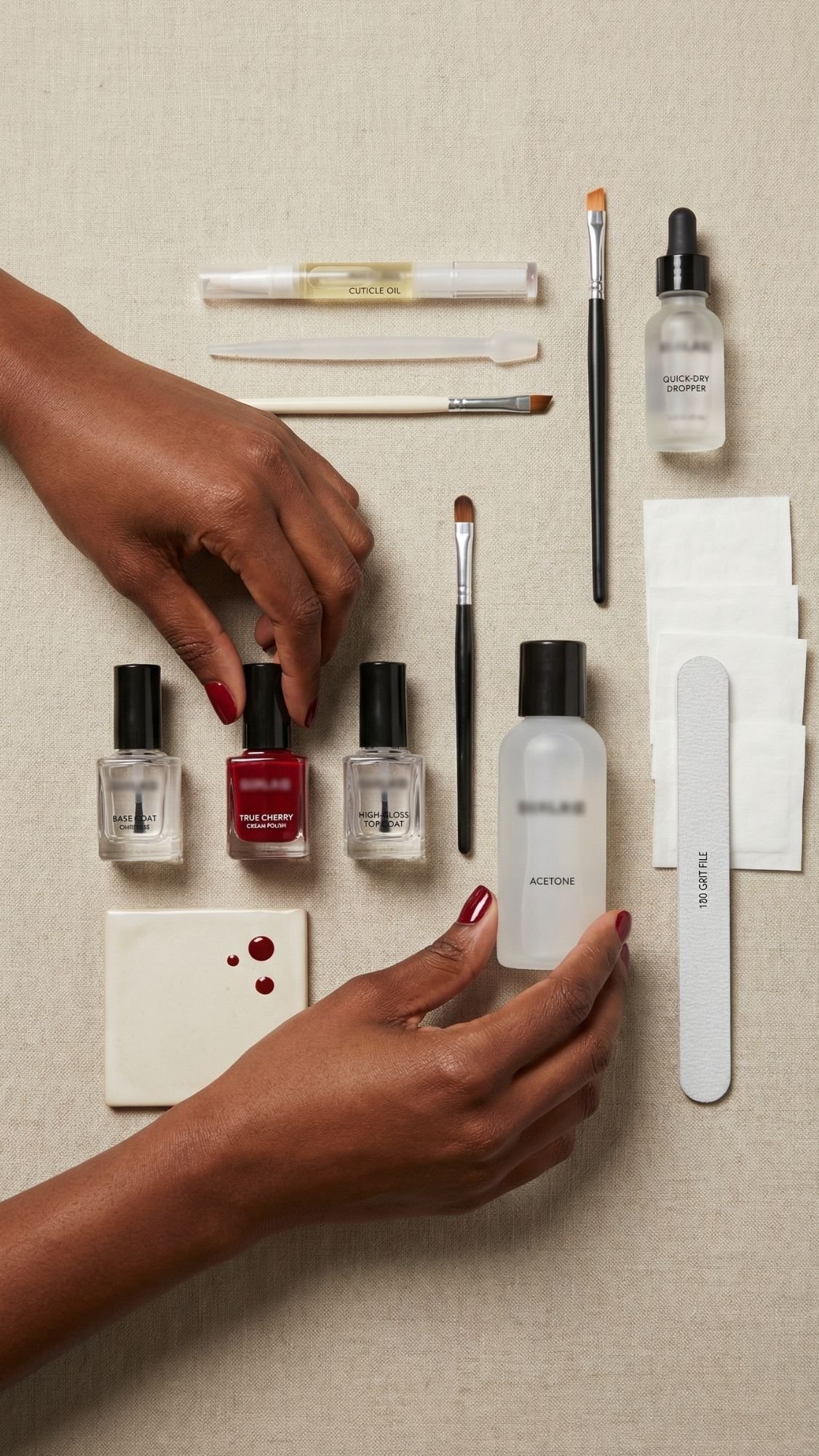 A person with red nails arranges nail care items, including bottles of polish, acetone, a nail file, cotton pads, and brushes, on a beige surface—perfect inspiration for fresh nail ideas.